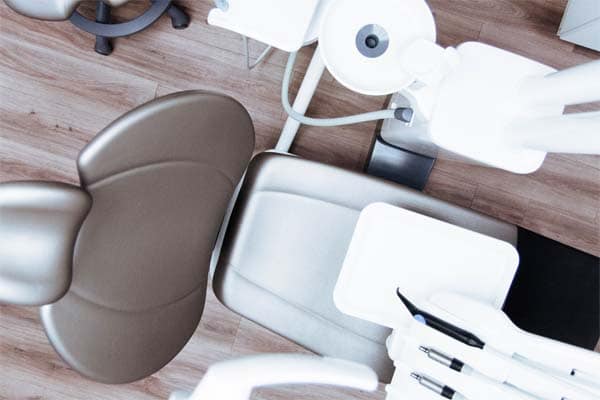 an overhead view of a dentists chair with attached dental tools.