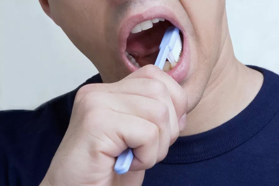 man brushing teeth